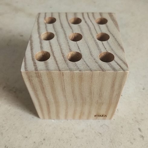 Paperweight made from wood with holes for storing pencils